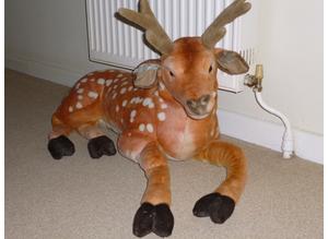 Life size soft toy deer in a "laying down position".,.